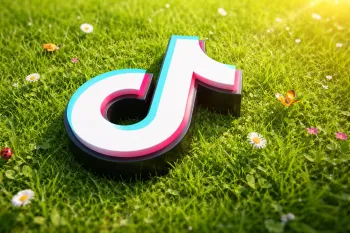 Объёмный логотип TikTok на фоне зелёной травы